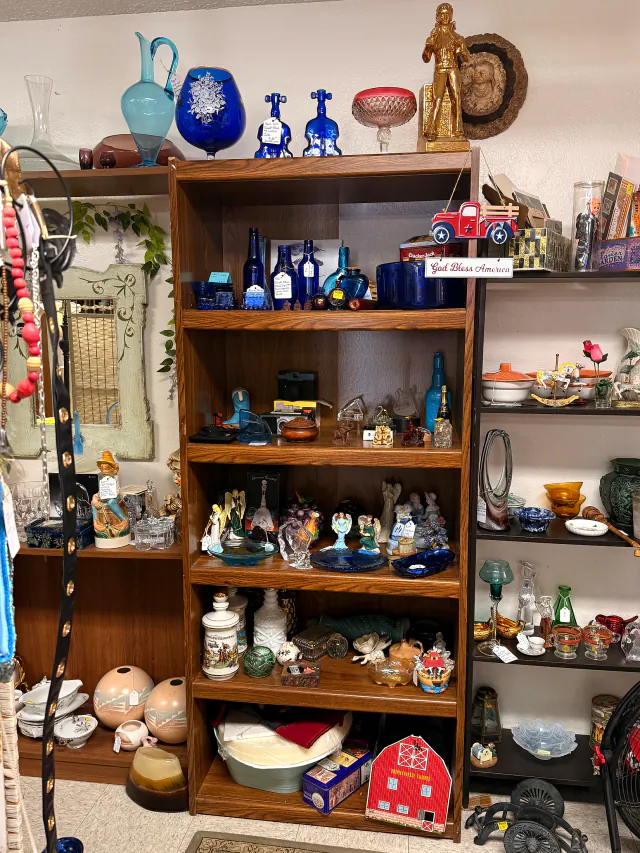 Blue glass and vintage decorative pieces displayed on shelves.