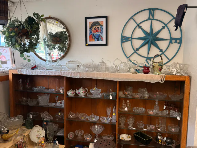 Glassware, framed art, and wall decor arranged by dealers at Unique Treasures.