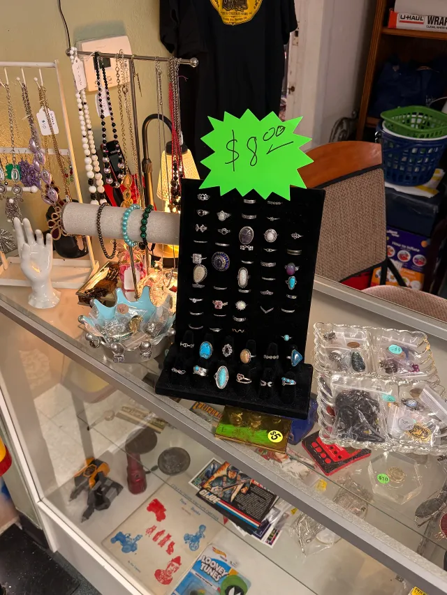 Rings, necklaces, and bracelets arranged in a jewelry display at Unique Treasures.